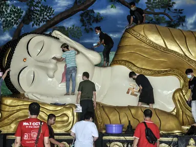 Warga keturunan Tionghoa membersihkan Patung Buddha Tidur di Wihara Buddha Dharma & 8 Pho Sat, Tajur Halang, Bogor, Jawa Barat, Minggu (23/1/2022). Kegiatan gotong royong membersihkan Patung Buddha Tidur ini merupakan tradisi dalam rangka menyambut Tahun Baru Imlek. (merdeka.com/Iqbal S. Nugroho)