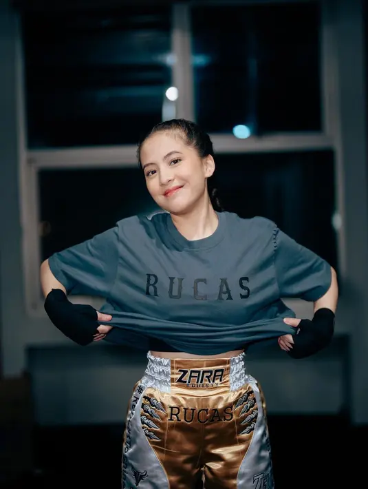 Beberapa waktu lalu, Zara sempat melakukan tanding tinju. Gaya sportynya sontak mengundang perhatian. Ia mengenakan crop top hitam yang ditumpuk dengan kaus abu-abu bertuliskan Rucas, dipadu mengenakan short pants putih dengan sentuhan warna emas yang juga dituliskan namanya. [Foto: Instagram/zaraadhsty]