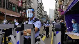 Petugas polisi berjaga di daerah Yau Ma Tei di Hong Kong, Sabtu (23/1/2021). Warga Hong Kong akan dilarang meninggalkan apartemen mereka kecuali dapat menunjukkan hasil negatif tes COVID-19 di mana dalam beberapa hari terakhir mengalami lonjakan kasus. (AP Photo/Vincent Yu)