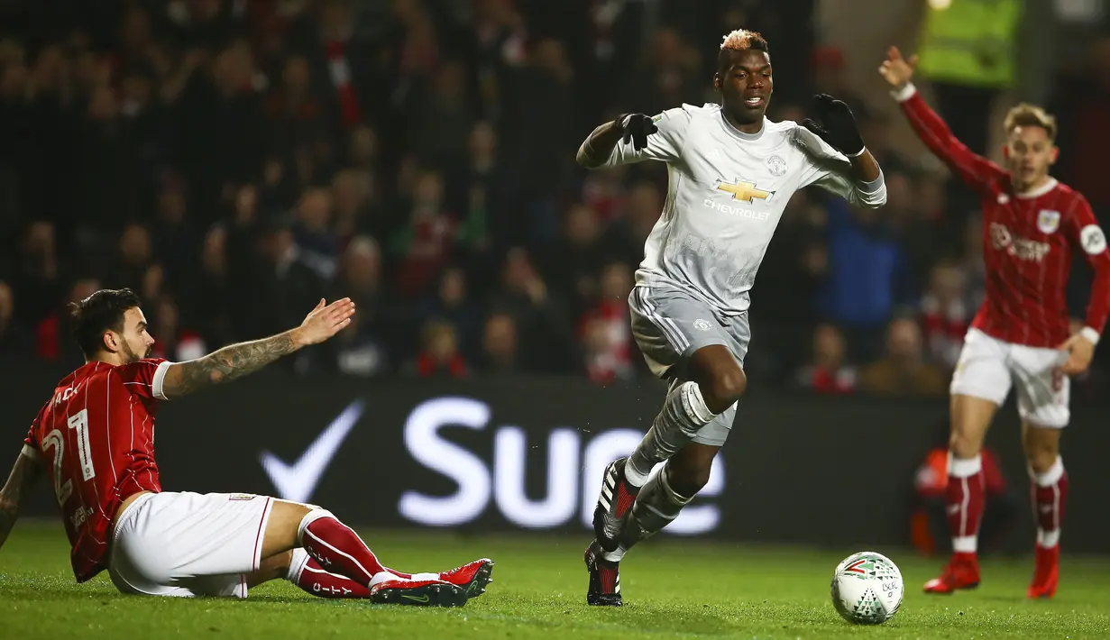Gelandang Manchester United, Paul merebut bola dari gelandang Bristol City, Marlon Pack pada perempat final Piala Liga Inggris di Ashton Gate, Kamis (21/12). MU gagal melangkah ke babak empat besar setelah kalah 1-2. (Geoff CADDICK / AFP)