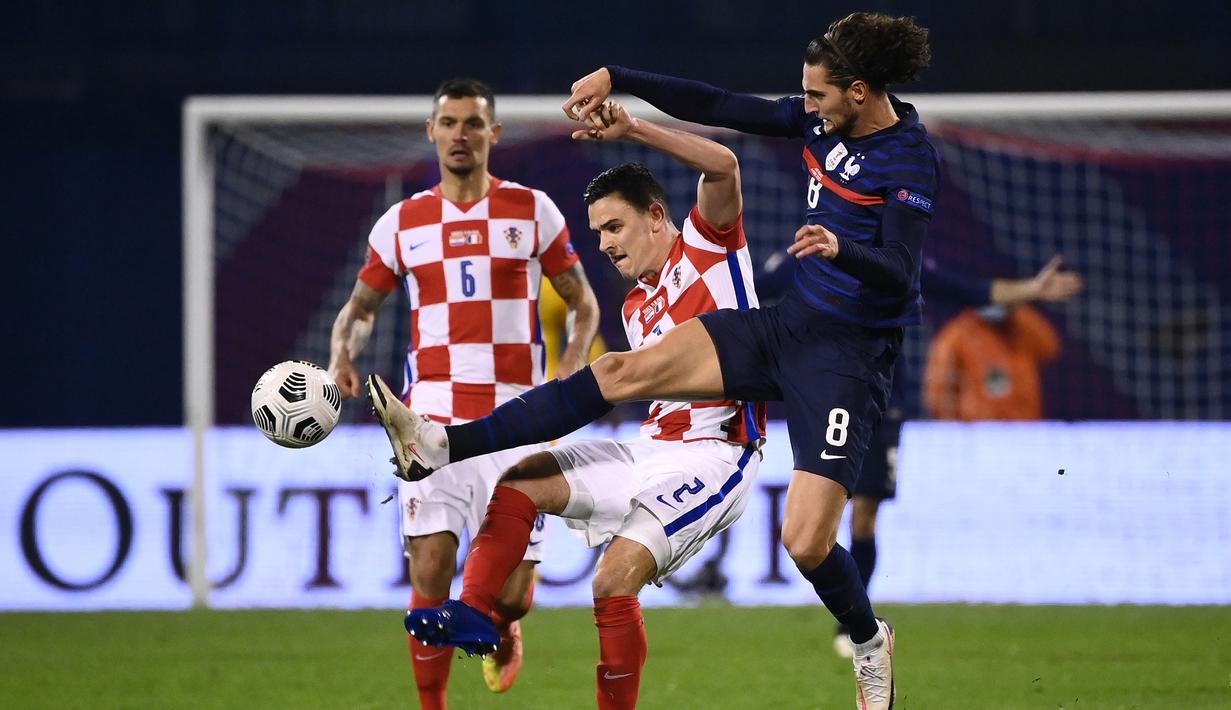 Gelandang Prancis, Adrien Rabiot, berebut bola dengan penyerang bek, Filip Uremovic, pada laga lanjutan UEFA Nations League 2020/2021 di Maksimir Stadium, Kamis (15/10/2020) dini hari WIB. Prancis menang 2-1 atas Kroasia. (AFP/Franck Fife)