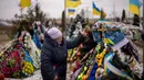 Maria Kurbet, 77 tahun, menangis di makam putranya, seorang prajurit militer yang gugur di Bakhmut, saat upacara peringatan satu tahun dimulainya perang Rusia-Ukraina, di sebuah pemakaman di Bucha, Ukraina, Jumat, 24 Februari 2023. (AP Photo/Emilio Morenatti)