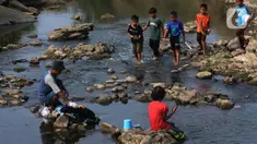 Warga mencuci pakaian pada aliran di pintu air Bendungan Cibeet, Wanajaya, Telukjambe, Karawang, Jawa Barat, Sabtu (7/10/2023). (merdeka.com/Imam Buhori)