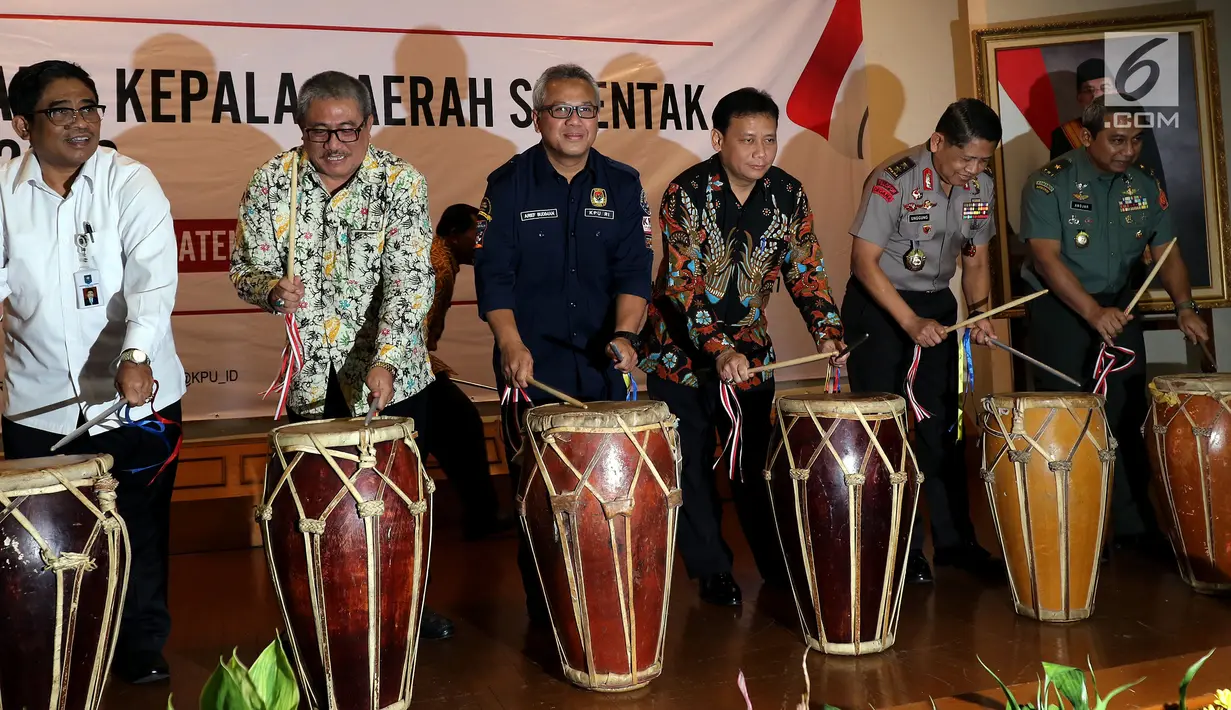Ketua KPU Arief Budiman (ketiga kiri) bersama sejumlah pejabat memukul beduk sebagai simbolis Peluncuran Pemilihan Kepala Daerah dan Wakil Kepala Daerah Serentak tahun 2018 di Gedung KPU, Menteng, Jakarta Pusat, Rabu (14/6). (Liputan6.com/JohanTallo)