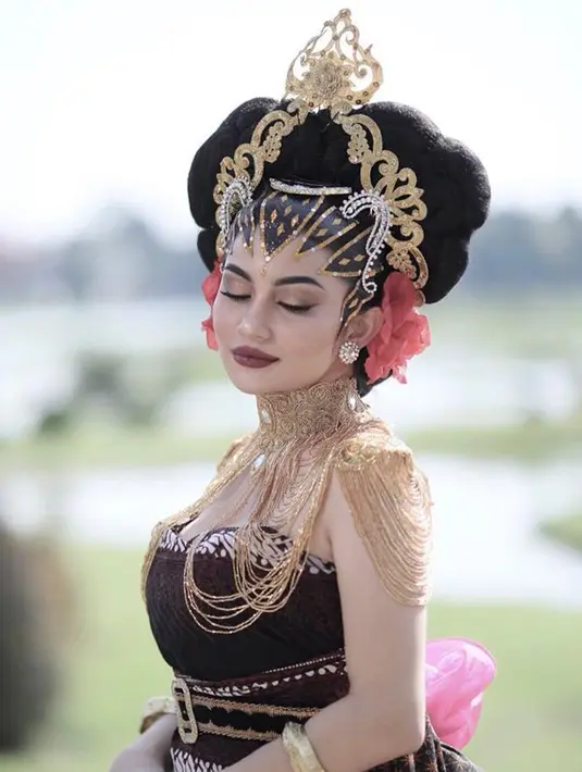 Ariel terlihat sangat anggun dengan mengenakan kemben dan kain batik lengkap dengan aksesoris berwarna emas. Selain itu, tatanan sanggul rambutnya yang terlihat unik. (Liputan6.com/IG/@arieltatum)