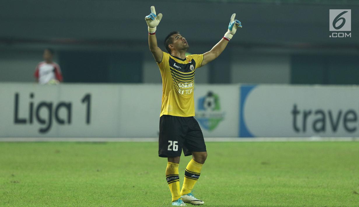 Penjaga gawang Persija, Andritany mengangkat tangan usai memenangi laga melawan Arema FC dilanjutan Liga 1 Indonesia di Stadion Patriot Candrabhaga, Bekasi, Jumat (2/6). Persija unggul 2-0 atas Arema FC. (Liputan6.com/Helmi Fithriansyah)