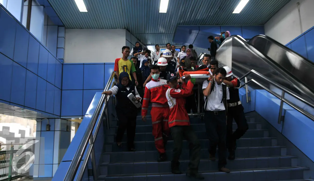 Petugas PMI dibantu aparat membawa Masinis menuruni anak tangga di  Stasiun Juanda, Jakarta, Kamis (23/9/2015). KRL nomor 1156 rute Kota - Bogor menabrak KRL 1154 tujuan sama saat tengah stand by di Stasiun Juanda. (Liputan6.com/Gempur M Surya)