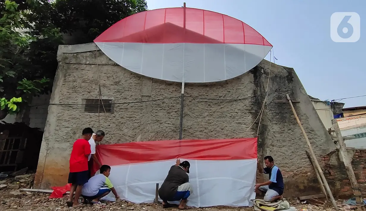 Warga membuat layang-layang merah putih setinggi enam meter di Kawasan Peninggilan, Tangerang, Senin (10/8/2020). Layang-layang merah putih tersebut dibuat untuk memeriahkan HUT Ke-75 Kemerdekaan Republik Indonesia. (Liputan6.com/Angga Yuniar)