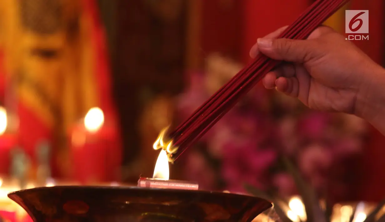 Warga membakar hio jelang melakukan sembahyang Imlek di Vihara Dhanagun, Bogor, Selasa (5/2). Sembahyang ini untuk memanjatkan doa keselamatan, kesehatan dan keberuntungan di tahun mendatang. (Liputan6.com/Helmi Fithriansyah)