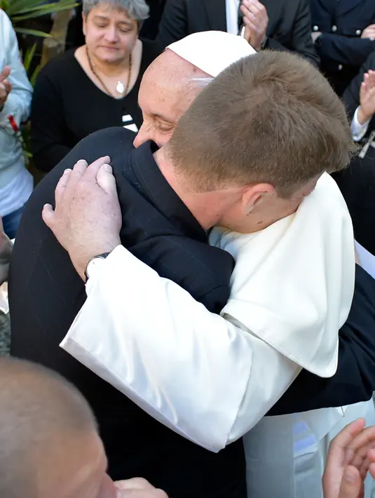 Paus Fransiskus berpelukan dengan narapidana di penjara Paliano selama perayaan Kamis Putih, Italia (13/4). Paus sebelumnya biasanya melakukan ritus pembasuhan kaki di Basilika di Vatikan atau Roma. (HO/OSSERVATORE ROMANO/AFP)