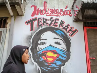 Warga melintas di depan mural bertuliskan "Indonesia terserah", di Kutabumi, Tangerang, Banten, Senin (27/5/2020). Mural dibuat sebagai bentuk kritik terhadap masyarakat yang tetap beraktivitas di luar ruangan tanpa prosedur protokol kesehatan di tengah wabah COVID-19. (Liputan6.com/Angga Yuniar)