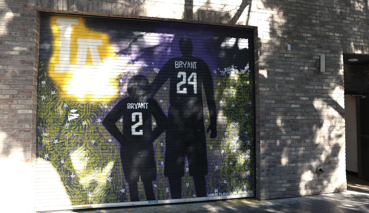 Lukisan mural bintang LA Lakers, Kobe Bryant bersama putrinya, Gianna terpampang di jalanan Los Angeles, California, Selasa (26/1/2021). Lukisan dibuat untuk mengenang 1 tahun tragedi kecelakaan helikopter yang menewaskan keduanya. (Getty Images via AFP/Rich Fury)
