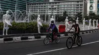 Pesepeda melintasi puluhan boneka maneken yang dipajang di Bundaran HI, Jakarta, Minggu (15/11/2020). Boneka maneken itu sebagai bentuk "Mengenang Korban Kecelakaan Lalu Lintas 2020" dan mengingatkan pengguna jalan agar selalu patuhi peraturan lalu lintas demi keselamatan. (Liputan6.com/Johan Tallo)