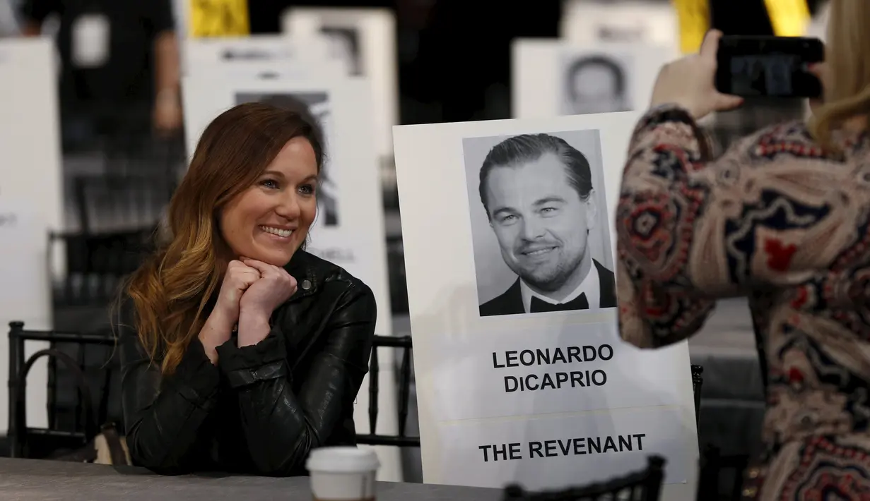 Zoe Ruderman, features Director at PEOPLE Magazine, berpose di dekat foto aktor Leonardo DiCaprio yang tertempel di bangku saat persiapan Screen Actors Guild Awards 2016 di Shrine Auditorium, Los Angeles, Jumat (29/1). (REUTERS/Mario Anzuoni)
