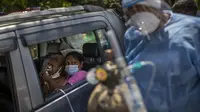 Seorang pasien menerima oksigen di dalam mobil yang disediakan oleh Gurdwara, tempat ibadah Sikh, di New Delhi, 24 April 2021. Banyak kota di India kewalahan oleh pasien yang mengakibatkan kekurangan tempat tidur rumah sakit dan oksigen yang menyebabkan ribuan kematian. (AP Photo/Rajesh Kumar Singh)