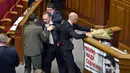 Sejumlah orang tampak menghalangi anggota parlemen bernama Oleg Barna yang tengah menyeret PM Arseny Yatsenyuk dari podium Majelis Tinggi Parlemen Ukraina, 11 Desember 2015. (REUTERS/Valentyn Ogirenko)