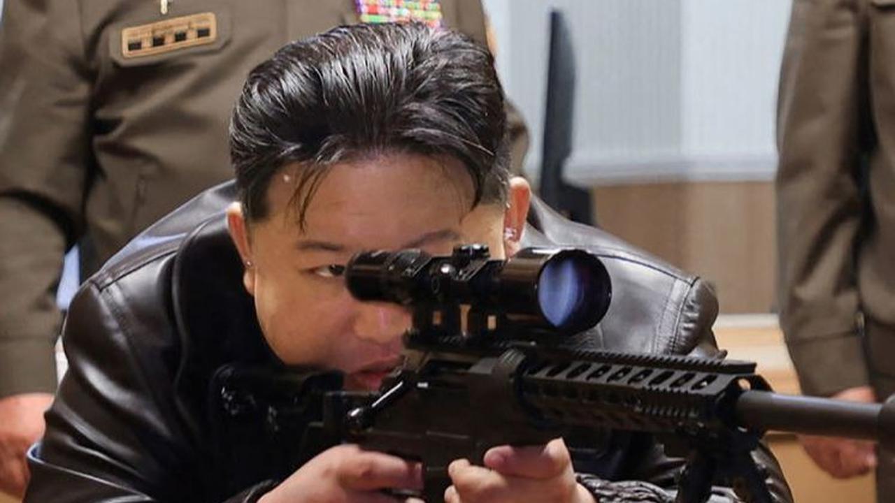 Dengan memicingkan mata kirinya, Kim mencermati target sembari menarik pelatuk. Gayanya tampak mirip seorang sniper yang menembak musuhnya.&nbsp;KCNA VIA KNS/AFP
