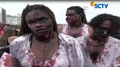 Dengan darah palsu dan pakaian yang menyeramkan, mereka berjalan di sekitar pantai seperti layaknya zombie hidup.