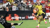 Penyerang Borussia Dortmund Donyell Malen mencetak gol ke gawang Manchester United yang dikawal Thomas Heaton pada pertandingan persahabatan pramusim di Allegiant Stadium, Las Vega, Nevada, Senin (30/7/2023). (Candice Ward/Getty Images/AFP)