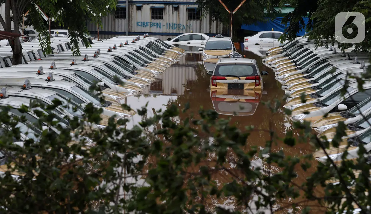 Kondisi dan suasana Pool Taksi Express di kawasan Tanah Kusir yang terendam banjir, Jakarta, Rabu (1/1/2020). Banjir akibat hujan deras yang mengguyur Jakarta dan sekitarnya sejak Selasa sore (31/12/2019) menyebabkan ratusan armada taksi terendam. (Liputan6.com/Johan Tallo)