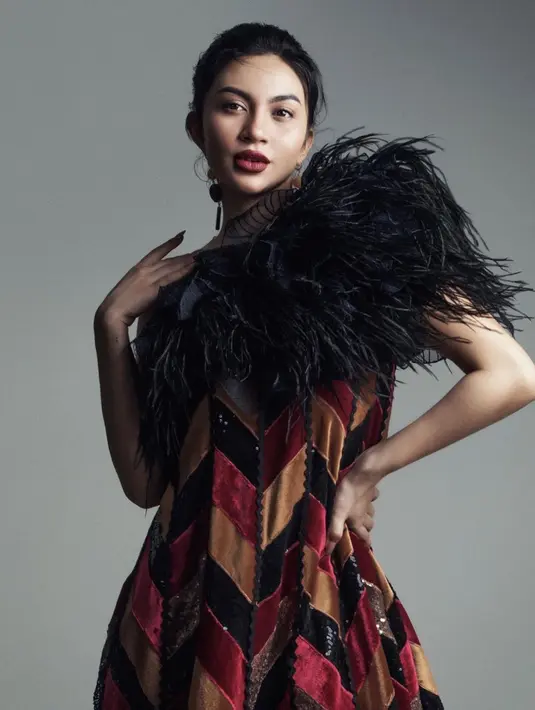 Ariel Tatum dengan dress megah bernuansa merah dan aksen bulu hitam di bagian dada. Dressnya ini memiliki detail asimetris yang menambah kesan edgy pada keseluruhan penampilannya. [Foto: Instagram/arieltatum]