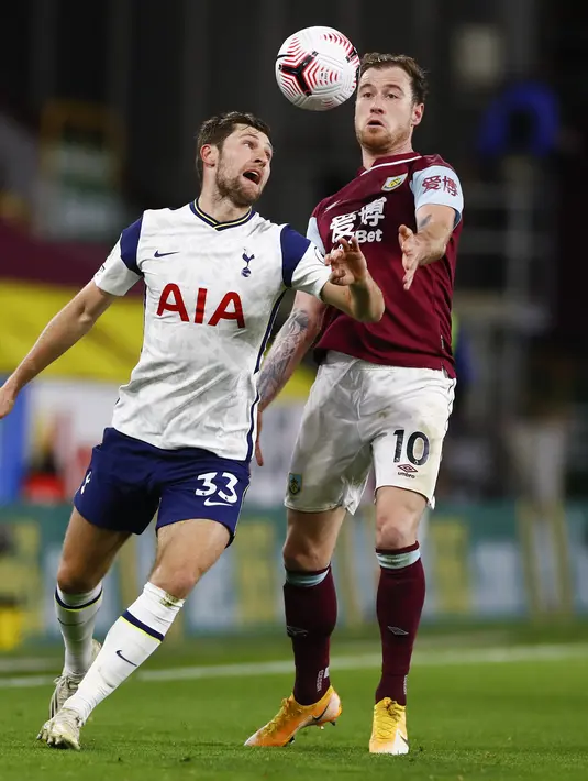 Pemain Tottenham Hotspur, Ben Davies berebut bola dengan pemain Burnley, Ashley Barnes pada pertandingan lanjutan Liga Inggris di stadion Turf Moor, Burnley, Inggris, Senin (26/10/2020). Tottenham menang tipis 1-0 atas Burnley. (Jason Cairnduff/Pool via AP)