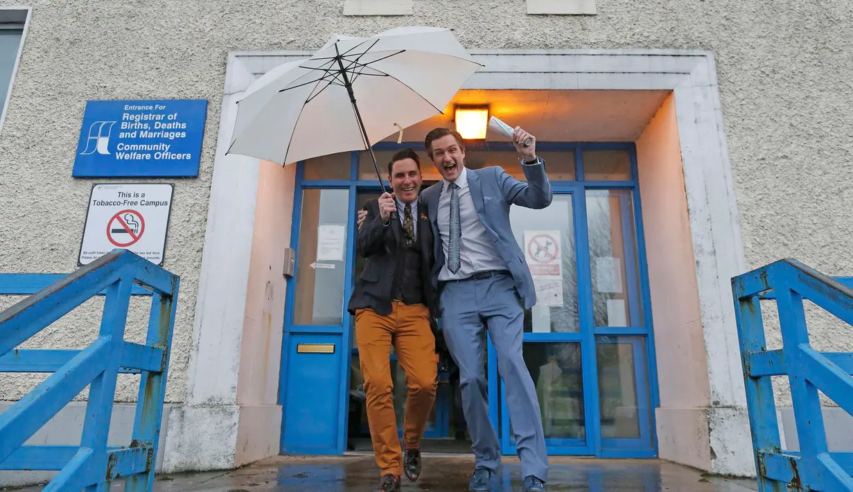 Richard Dowlin (kiri) dan Cormac Gollogly usai melangsungkan pernikahan di kantor the South Clonmel Community Care Centre di Irlandia, (17/11/2015). Dowlin dan Gollogly adalah pasangan gay pertama yang menikah di Irlandia. (REUTERS/Cathal McNaughton)