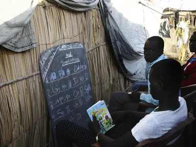 Para pengungsi Sudan Selatan mengikuti pelajaran membaca di kamp UNHCR al-Algaya di negara bagian Nil Putih Sudan, selatan Khartoum, (17/5). Tahun ini Lebih dari 95.000 orang Sudan Selatan telah mengungsi. (AFP Photo/Ashraf Shazly)
