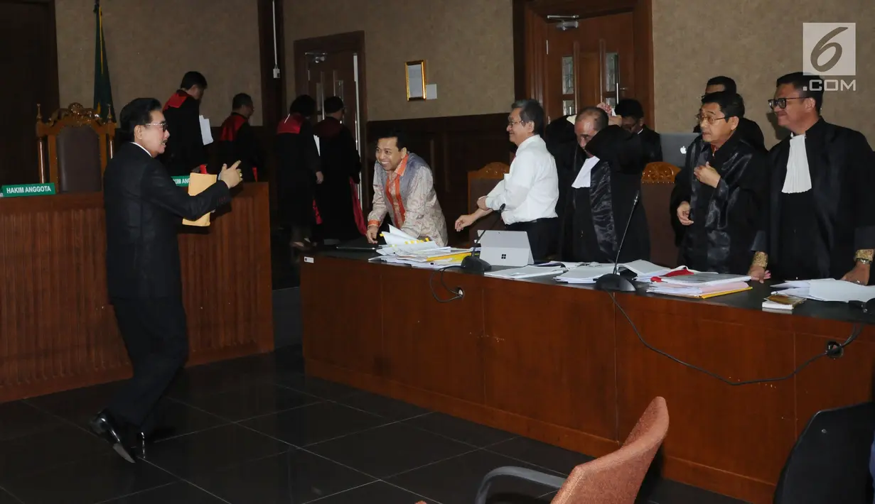 Pengacara Hotma Sitompul (kiri) menghampiri terdakwa dugaan korupsi proyek e-KTP, Setya Novanto saat jeda persidangan di Pengadilan Tipikor, Jakarta, Kamis (1/2). Sidang mendengar keterangan saksi. (Liputan6.com/Helmi Fithriansyah)