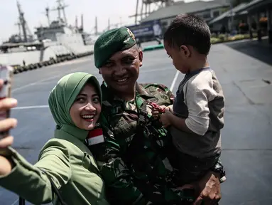 Seorang personel TNI-AD berselfie bersama keluarganya di Pelabuhan Kolinlamil, Jakarta, Senin (9/5). Sebanyak 450 personel TNI-AD dari Satgas Yonif Para Raider 330 inf 1 Kostrad dilepas untuk misi pengamanan perbatasan RI-PNG. (Liputan6.com/Faizal Fanani)