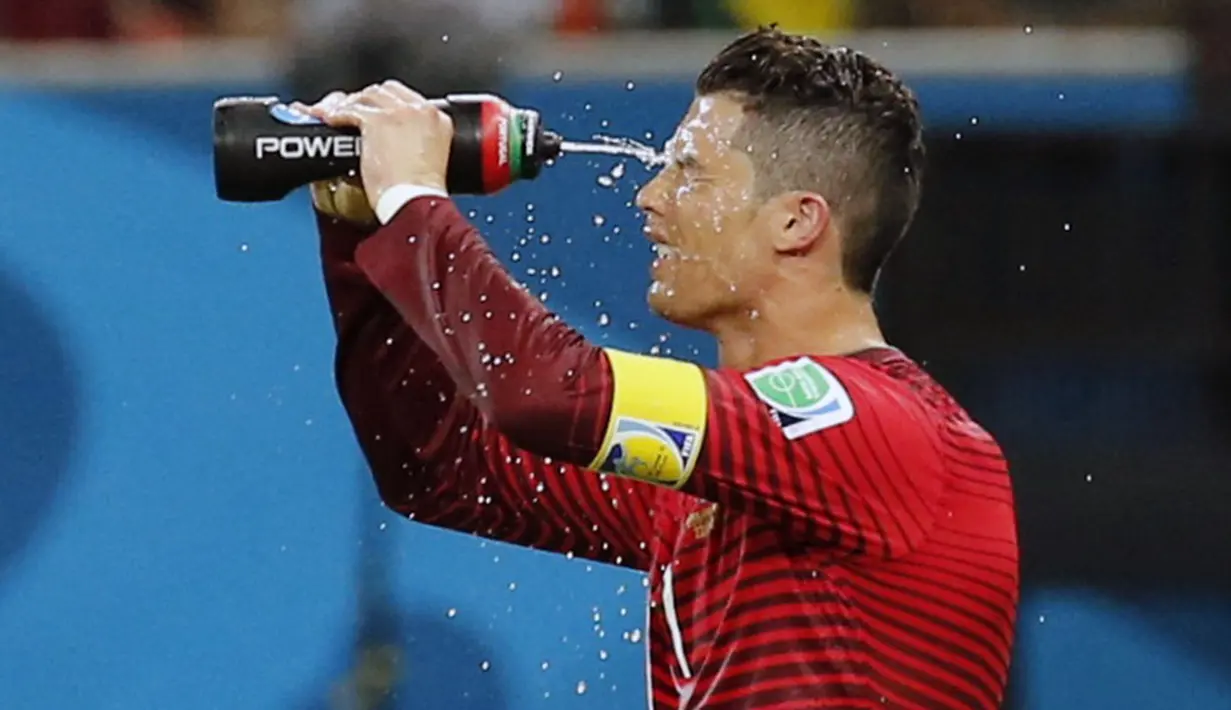 Pemain depan Timnas Portugal, Cristiano Ronaldo, menyemprotkan air ke wajahnya disela-sela laga melawan Amerika Serikat di Stadion Amazonia, Brasil, (23/6/2014). (REUTERS/Siphiwe Sibeko)