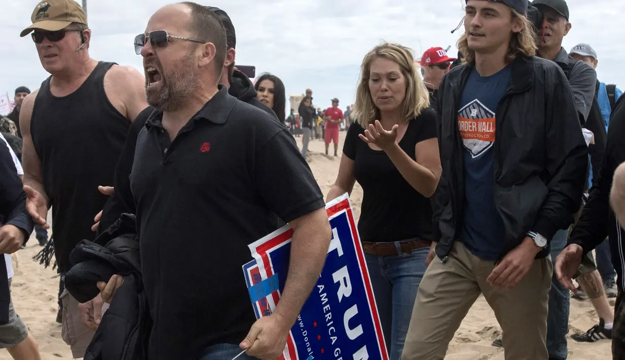 Para pendukung Presiden Donald Trump berteriak kearah demonstran anti-Trump dalam bentrokan di Huntington Beach, California (25/3). (Mindy Schauer / The Orange County Register via AP)