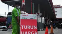Petugas membawa papan informasi harga turun di SPBU di Jakarta, Selasa (3/1/2023).Selain menurunkan harga Pertamax, pemerintah juga menurunkan harga Pertamax Turbo (RON 98) yang turun harga dari Rp15.200 per liter menjadi Rp14.180 per liter sejak penyesuaian harga terakhir. (Liputan6.com/Angga Yuniar)