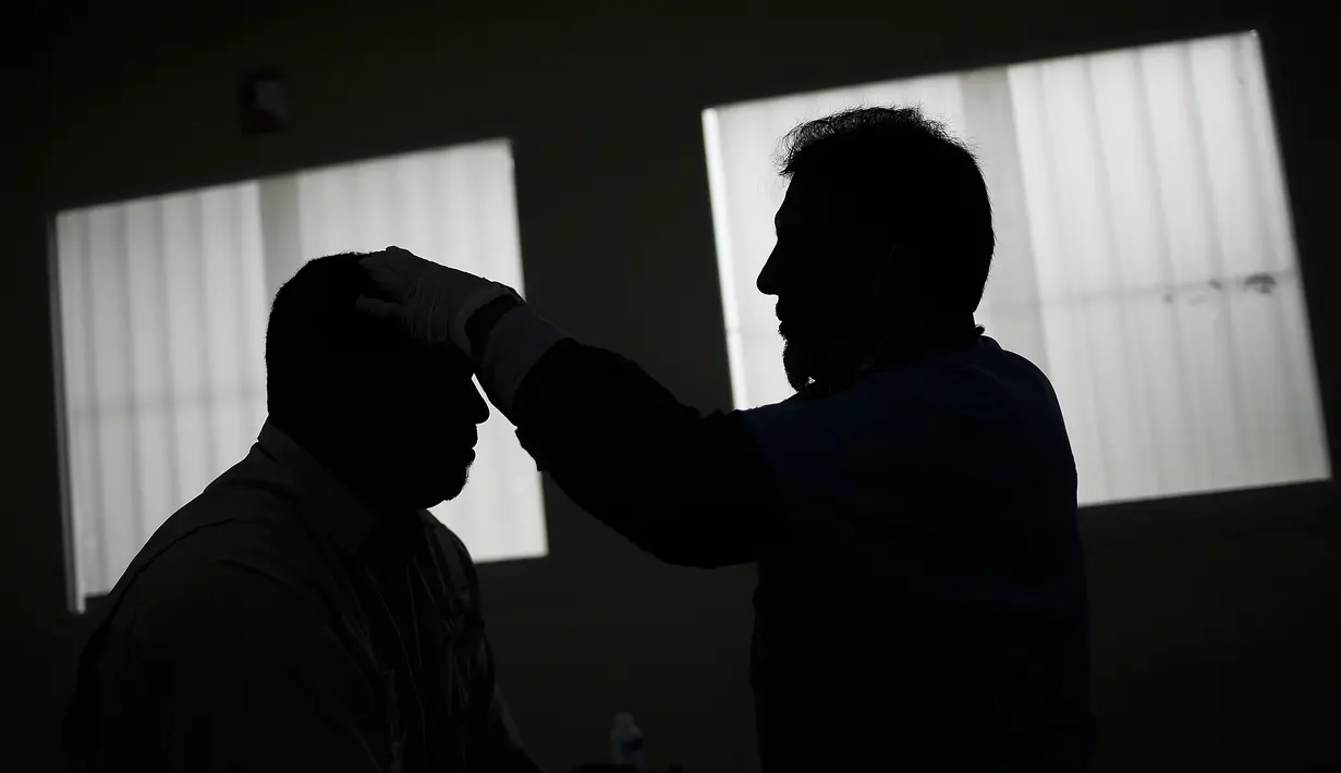 Seorang dokter melakukan terapi akupunktur pada pasien terpapar virus Corona COVID-19 yang baru pulih di pusat kesehatan yang dikelola pemerintah di lingkungan Coche di Caracas, Venezuela pada 25 Februari 2021. (AP Photo / Matias Delacroix)