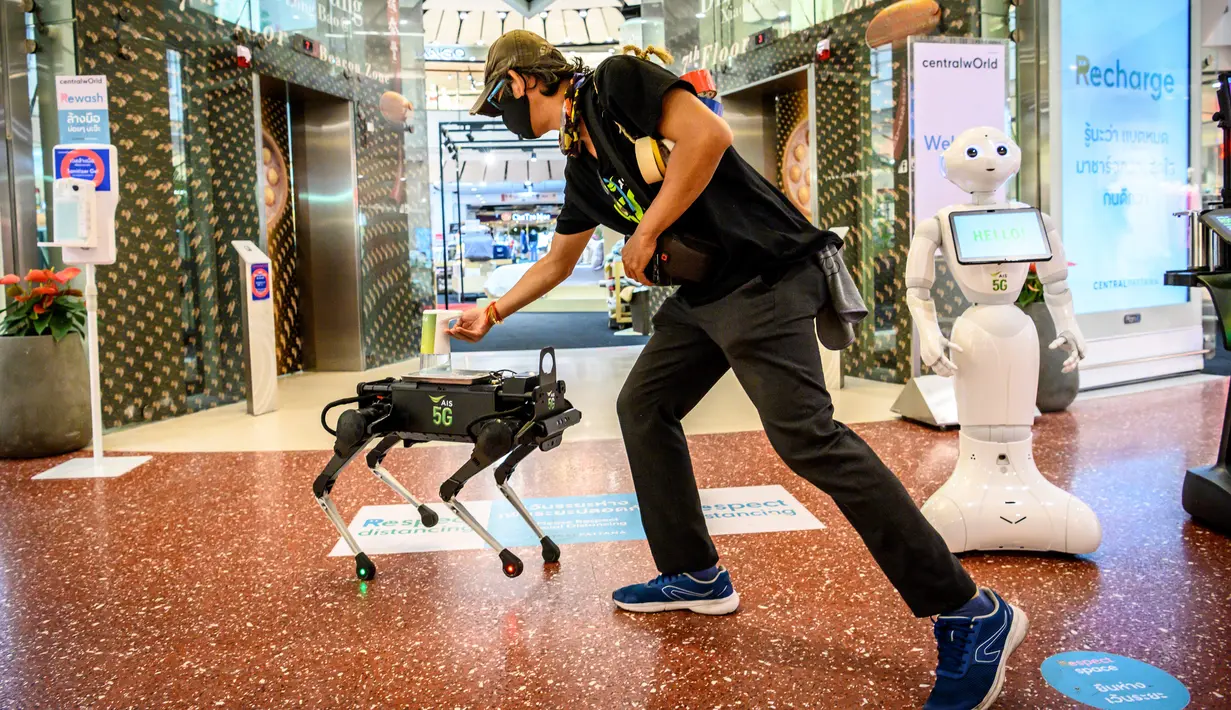 Robot 5G K9 memberikan hand sanitiser atau cairan pembersih tangan kepada pengunjung di pusat perbelanjaan di Bangkok, Kamis (4/6/2020). Thailand menggunakan teknologi di garis depan untuk menjaga ruang publik dari penyebaran pandemi corona Covid-19. (Mladen ANTONOV / AFP)