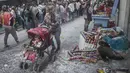 Orang-orang bermain dengan bubuk dan busa di jalan selama Karnaval Hitam dan Putih di Pasto, Kolombia (6/1/2022). Karnaval Hitam Putih dirayakan setiap tahun dan telah masuk dalam daftar warisan budaya takbenda UNESCO sejak 2009. (AFP/Joaqin Sarmiento)