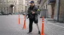 Seorang pria pertahanan sipil bersenjata berpatroli di jalan yang kosong karena jam malam di Kiev, Ukraina, Minggu (27/2/2022). Pihak berwenang Ukraina mengatakan bahwa pasukan Rusia telah memasuki kota terbesar kedua di Ukraina Kharkiv dan pertempuran di jalan-jalan. (AP Photo/Efrem Lukatsky)