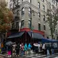 Orang-orang mengantre untuk memberikan penghormatan kepada aktor Matthew Perry di luar gedung apartemen yang digunakan sebagai pengambilan gambar eksterior dalam acara TV "Friends" di New York pada 29 Oktober 2023. (Adam GRAY / AFP)