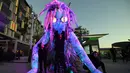 Pemain menunjukkan makhluk misterius setinggi enam meter berhias cahaya saat pratinjau Festival Vivid Sydney di Barangaroo, Sydney, Australia, Rabu (23/5). Festival Vivid Sydney berlangsung pada 25 Mei hingga 16 Juni 2018. (Saeed KHAN/AFP)