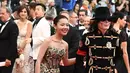 Seorang pria berpenampilan Michael Jackson didampingi wanita cantik menghadiri pemutaran film Solo: A Star Wars Story di Festival Film Cannes, Prancis, Selasa (15/5). Belum diketahui dengan pasti siapa pria tersebut. (AFP/Anne-Christine POUJOULAT)