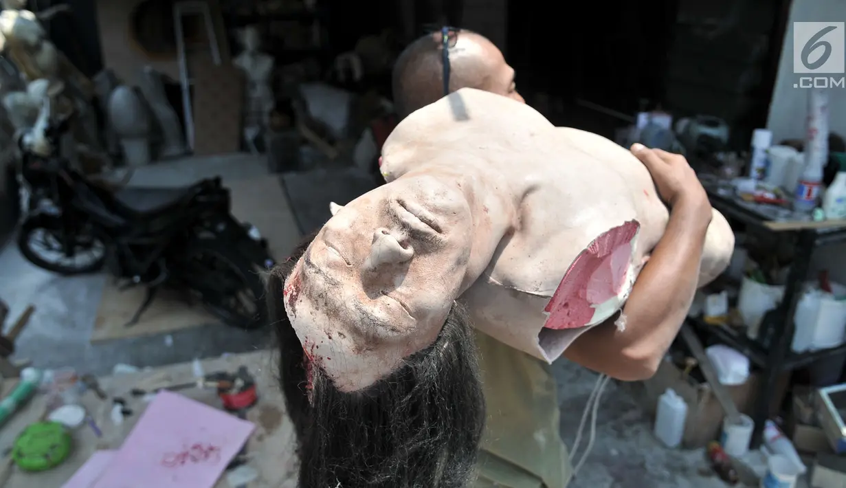 Kocom menggendong patung prostetik di kawasan Bekasi, Jawa Barat, Senin (24/9). Untuk satu buah boneka prostetik, Kocom mampu menyelesaikannya dalam waktu 15 hari yang dijual dengan kisaran mulai Rp 1 juta hingga Rp 15 juta. Merdeka.com/ Iqbal S. Nugroho)