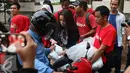 Vokalis Band Geisha Momo membagikan takjil ke pengendara yang melintas di kawasan Perdatam, Jakarta, Rabu (22/6). Memperingati bulan Ramadan Band Geisha dan Fansnya "My Geisha" membagi - bagi Takjil kepada pengendara. (Liputan6.com/Herman Zakharia)
