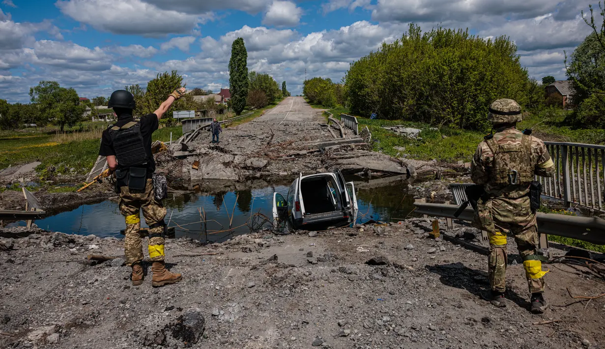 <p>Prajurit unit pasukan khusus Ukraina Kraken berbicara dengan seorang pria di jembatan yang hancur di jalan dekat desa Rus'ka Lozova, utara Kharkiv, pada 16 Mei 2022. Ukraina mengatakan pasukannya telah menguasai kembali wilayah di Perbatasan Rusia dekat kota terbesar kedua di negara itu Kharkiv, yang terus-menerus diserang sejak invasi Moskow dimulai. (Dimitar DILKOFF / AFP)</p>