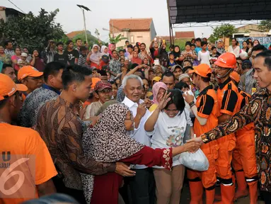 Warga antri untuk bersalaman dengan Presiden RI Joko Widodo di Lapangan Bedeng, Pisangan Baru, Jakarta, Selasa (8/9/2015). Kedatangan Presiden Jokowi untuk memberikan sejumlah paket sembako dan buku kepada warga. (Liputan6.com/Helmi Fithriansyah)
