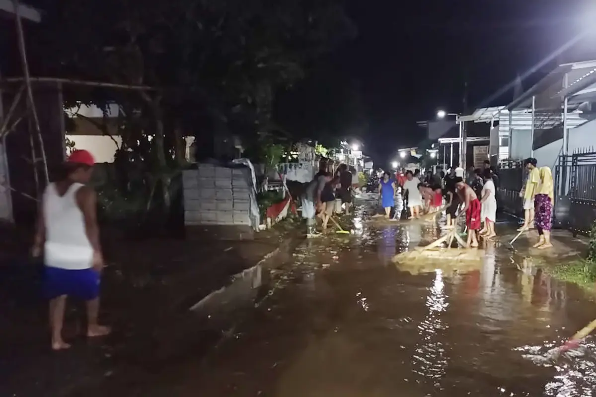Warga Desa Kutorenon Lumajang membersihkan material banjir yang menggenangi area rumahnya (Istimewa)