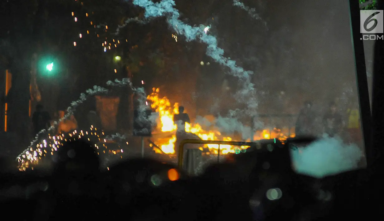 Polisi menembakan gas air mata ke arah massa di kawasan Tanah Abang, Jakarta Pusat, Rabu (22/5/2019). Massa terus melakukan perlawanan pasca buntut dari unjuk rasa hasil penghitungan suara Pemilu 2019 di depan kantor Bawaslu. (Liputan6.com/Herman Zakharia)