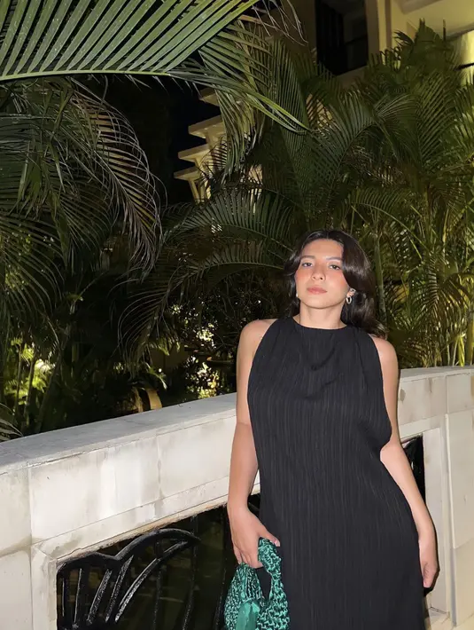 Meskipun hitam menjadi dominasi gayanya, ia berhasil tampil memukau. Material pleats mengangkat kesempurnaan gaya. Aksen tas rajut juga ciptakan gaya yang tak biasa. [Foto: Instagran/ Shaloom Razardee]