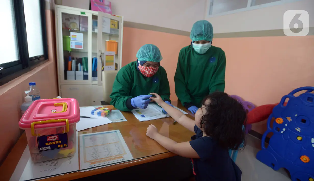 Dokter memeriksa stimulasi deteksi dan intervensi dini tumbuh kembang anak usia 5 dan 2 tahun di Puskesmas Kramat Jati, Jakarta, Kamis (12/11/2020). Pemantauan pertumbuhan balita dan batita dilakukan dengan imunisasi secara rutin pada anak usia 0-9 bulan dan 18 bulan. (merdeka.com/Imam Buhori)