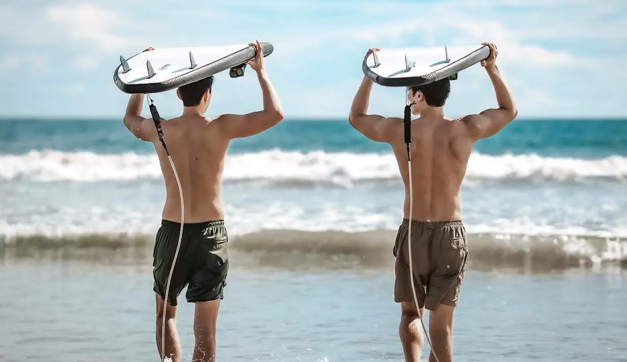 Ahn Bo Hyun antusias berlari menuju pantai lepas untuk bermain surfing bersama temannya. Dia memperlihatkan otot punggungnya. (Foto: Instagram/ bohyunahn)