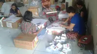 Warga setempat melipat surat suara untuk Pilkada di Papua. (Katharina Janur/Liputan6.com)